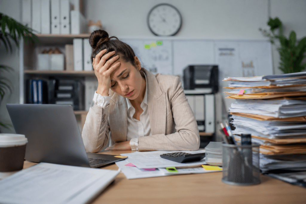 Femme stressée au travail débordée par les dossiers